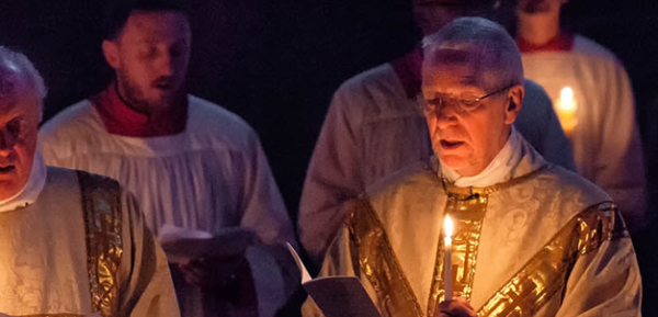 Close-up wide-shot of clergy and servers during Easter Vigil mass.