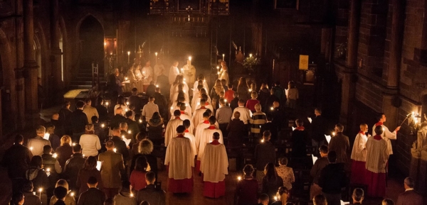 Clergy & choir processing to altar during Easter Vigil mass & lighting candles on way.