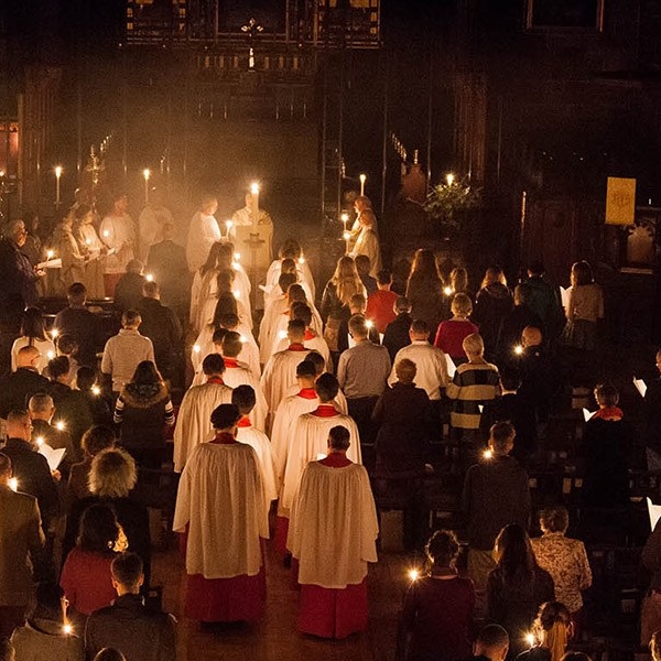 Clergy & choir processing to altar during Easter Vigil mass & lighting candles on way.