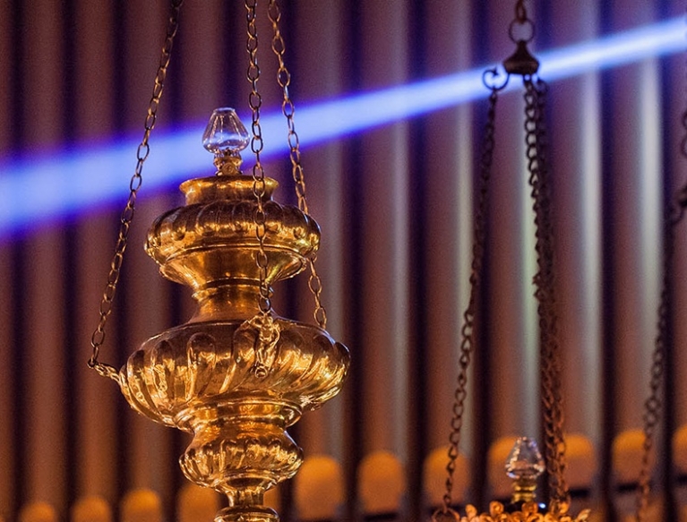 Close up of chancel sanctuary lamps hanging by organ.