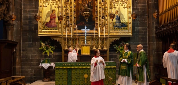 Robed servers and clergy near altar preparing for mass.