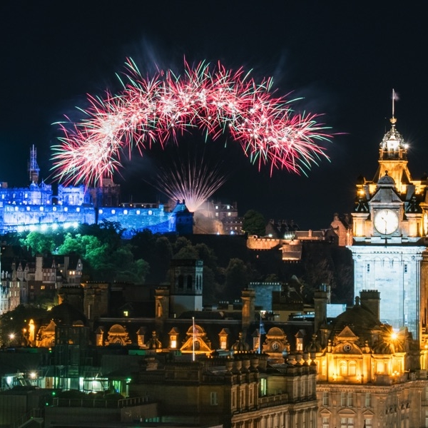 Fireworks in night sky over Edinburgh castle and Princes Street.