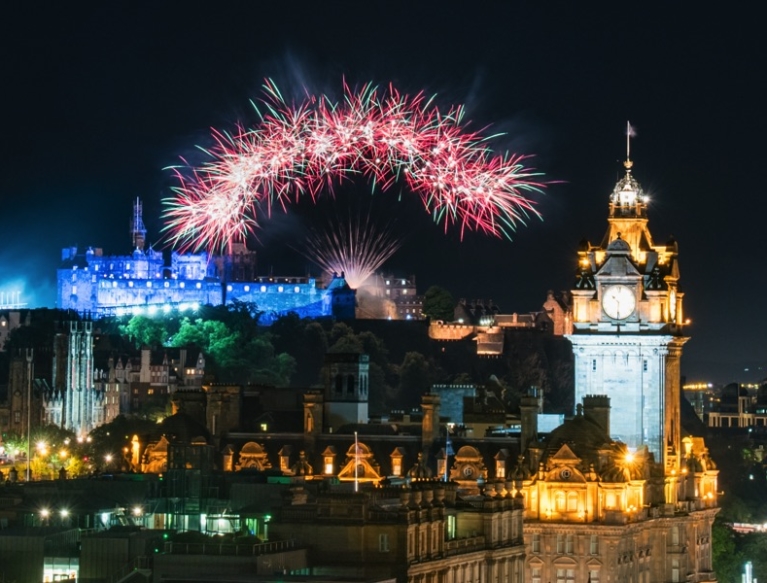 Fireworks in night sky over Edinburgh castle and Princes Street.
