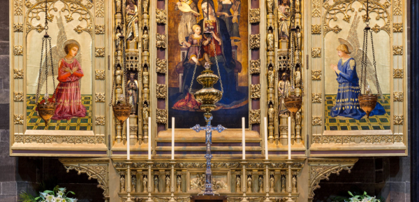 Reredos (triptych screen behind altar) designed by Hay & Henderson and featuring a copy of Virgin and Child with Saints by Benvenuto di Giovanni, with candles for mass.