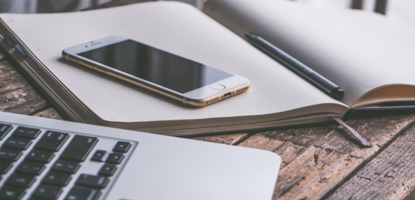 Tools for online worship: laptop, mobile phone, old-fashioned record book.