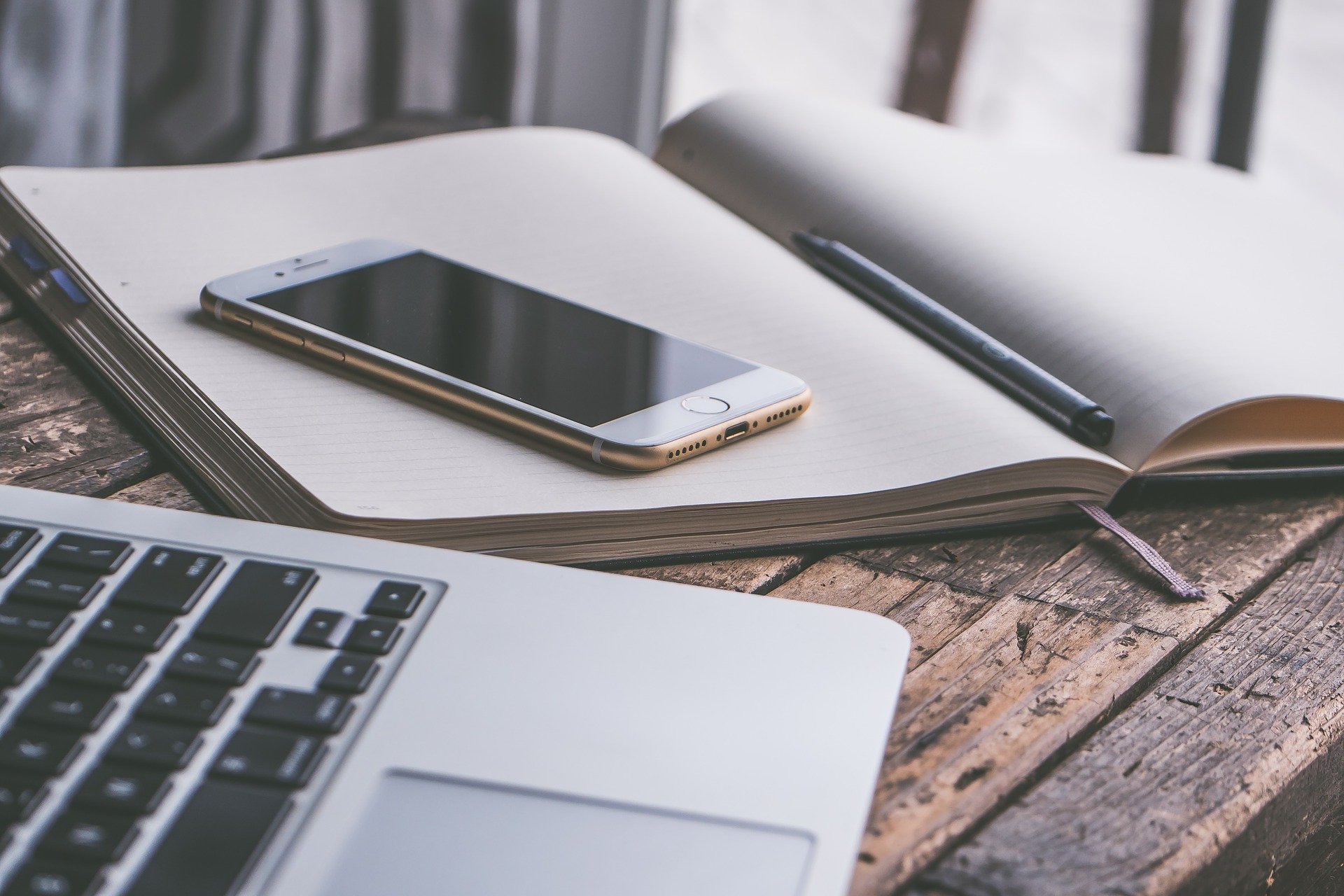 Tools for online worship: laptop, mobile phone, old-fashioned record book.