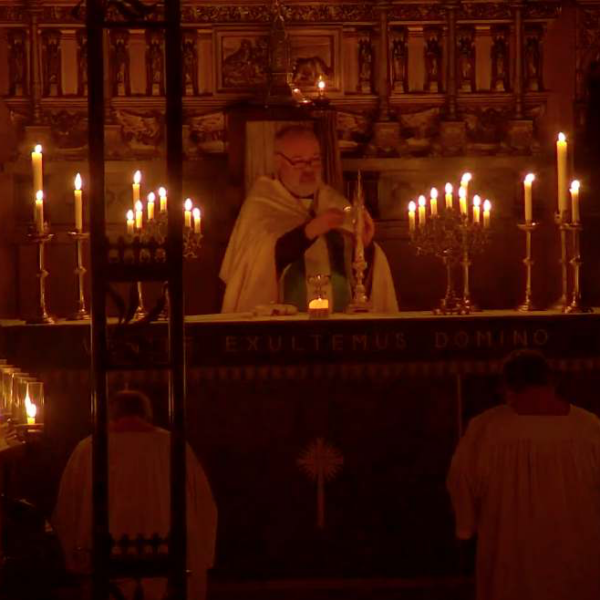 Father John ministering at the altar by the candlelight